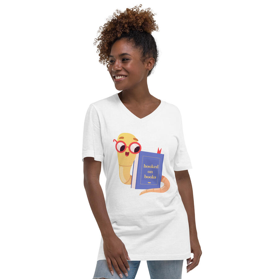 Black woman wearing a white v neck t-shirt featuring an illustration of a worm wearing glasses wrapped around a book titled "Hooked on Books"