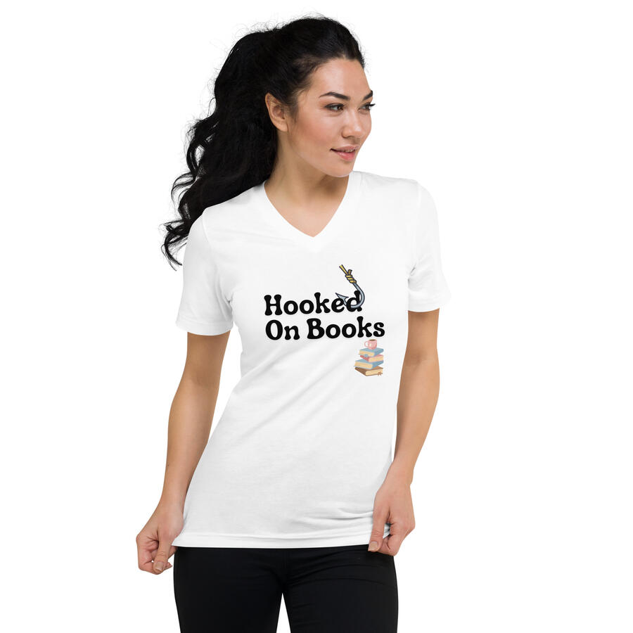 Image of Asian woman wearing a white v-neck t-shirt featuring the phrase "Hooked On Books" with a fish hook through the "d" and a stack of illustrated books underneath